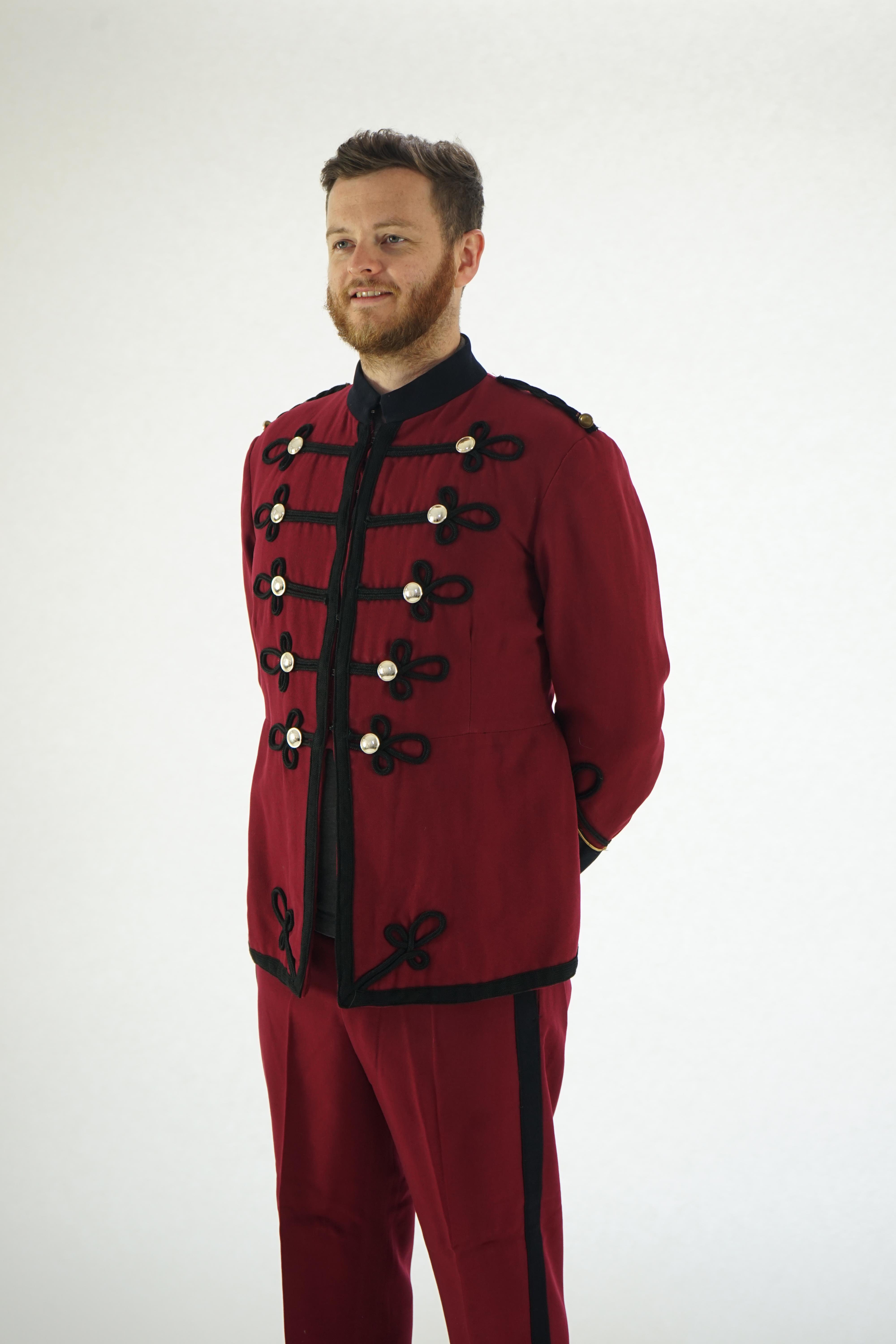 An early 20th century burgundy and black trim Military/Bandsman's uniform jacket and trousers.